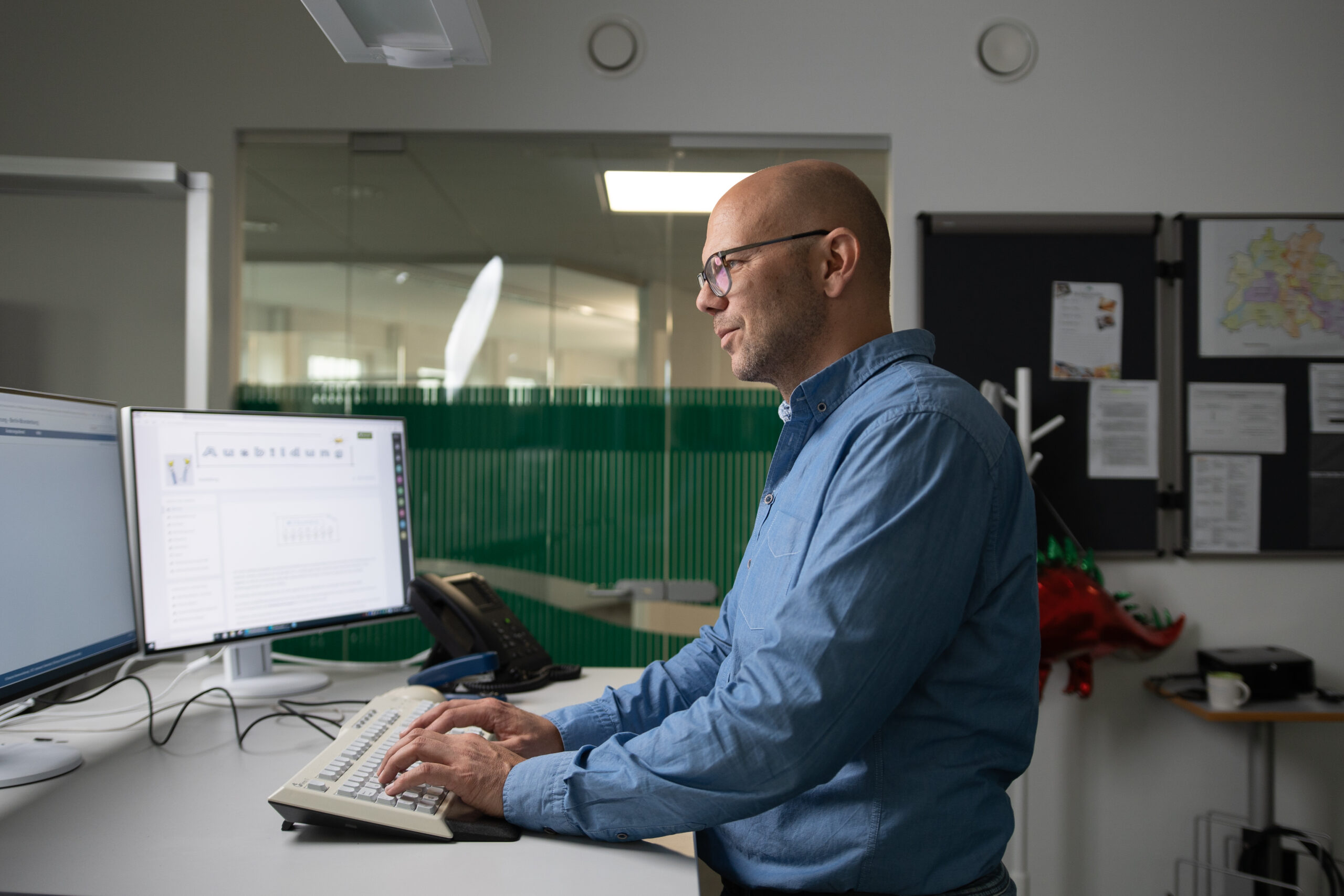 Ein Mitarbeiter der Deutschen Rentenversicherung Berlin-Brandenburg arbeitet stehend am Computer